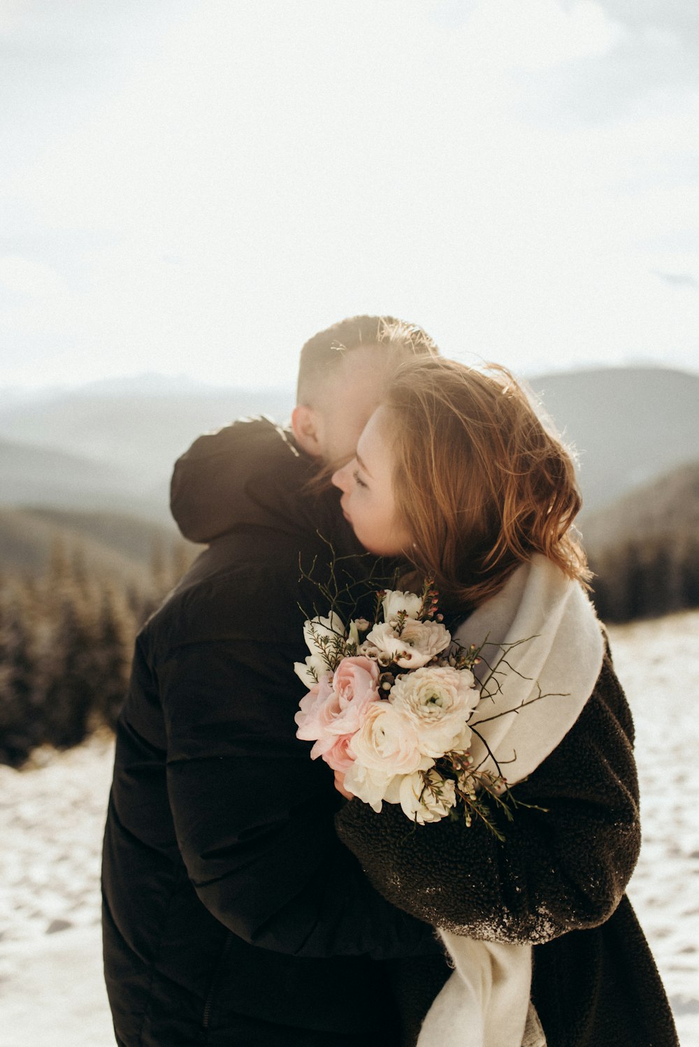 a couple embracing each other in the snow