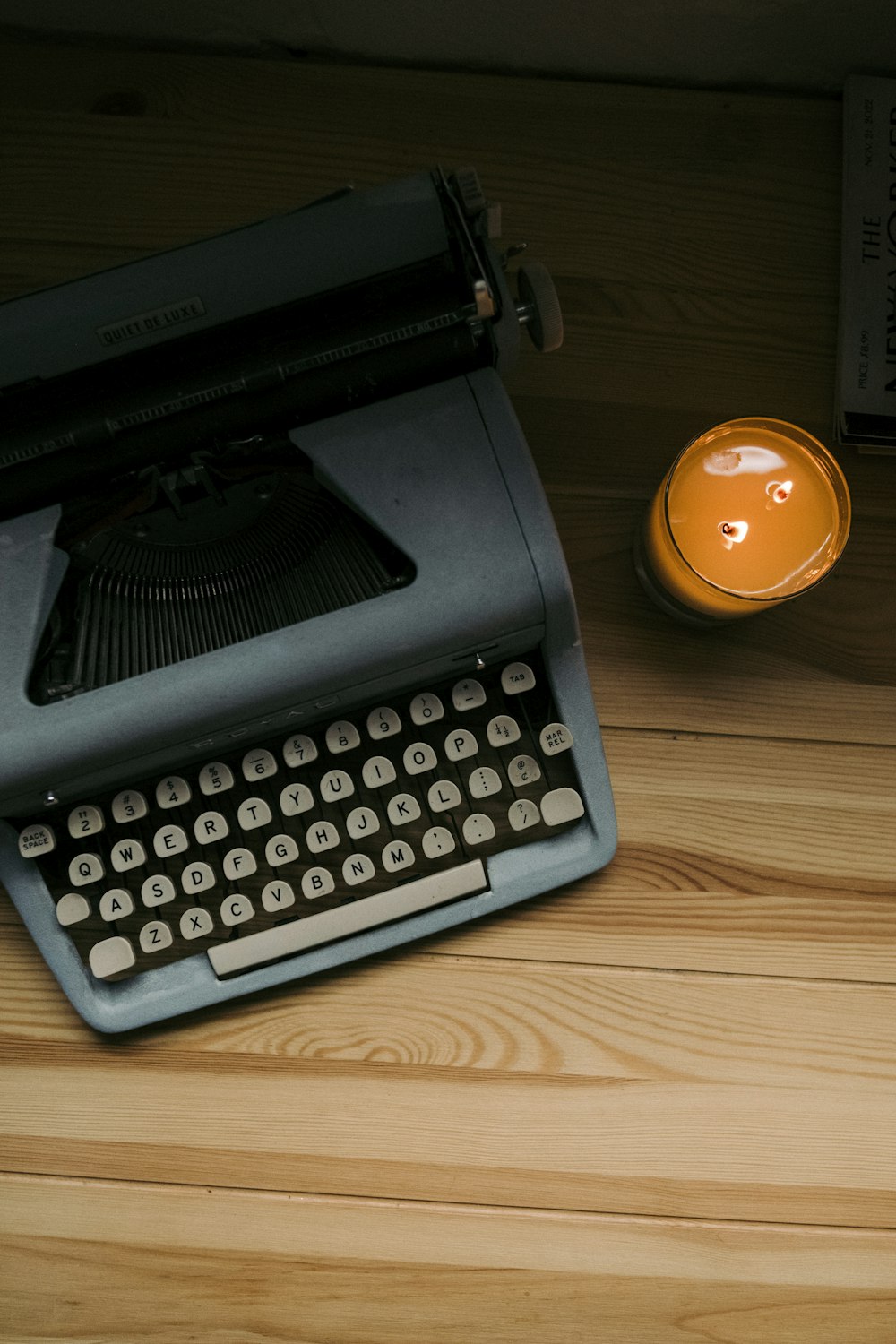 an old fashioned typewriter next to a candle
