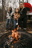 A family gathered around a campfire sharing stories and roasting marshmallows.