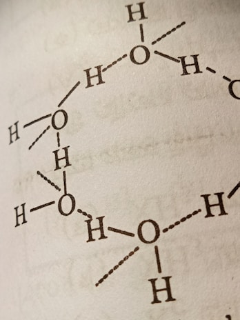 A close-up view of a molecular structure diagram on a page, featuring interconnected atomic symbols, primarily representing oxygen and hydrogen atoms with bonds indicated by lines and dots.