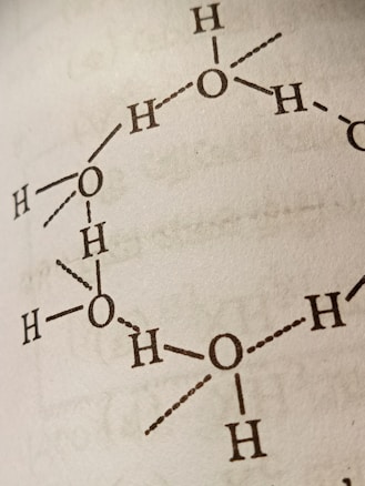 A close-up view of a molecular structure diagram on a page, featuring interconnected atomic symbols, primarily representing oxygen and hydrogen atoms with bonds indicated by lines and dots.