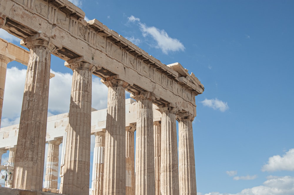 a large stone building with columns and a sky background