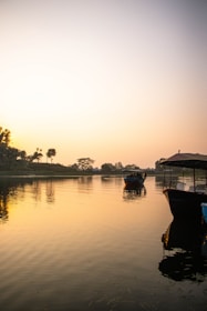 A peaceful river scene at dawn with boats gently floating on the water.