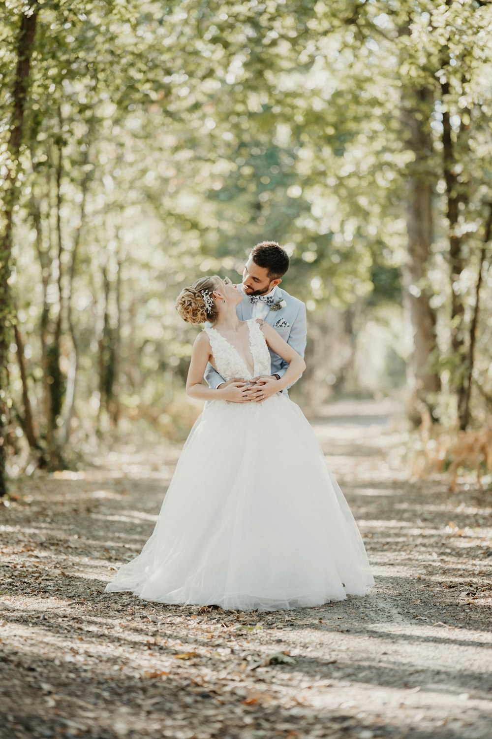 Una novia y un novio parados en medio de un bosque
