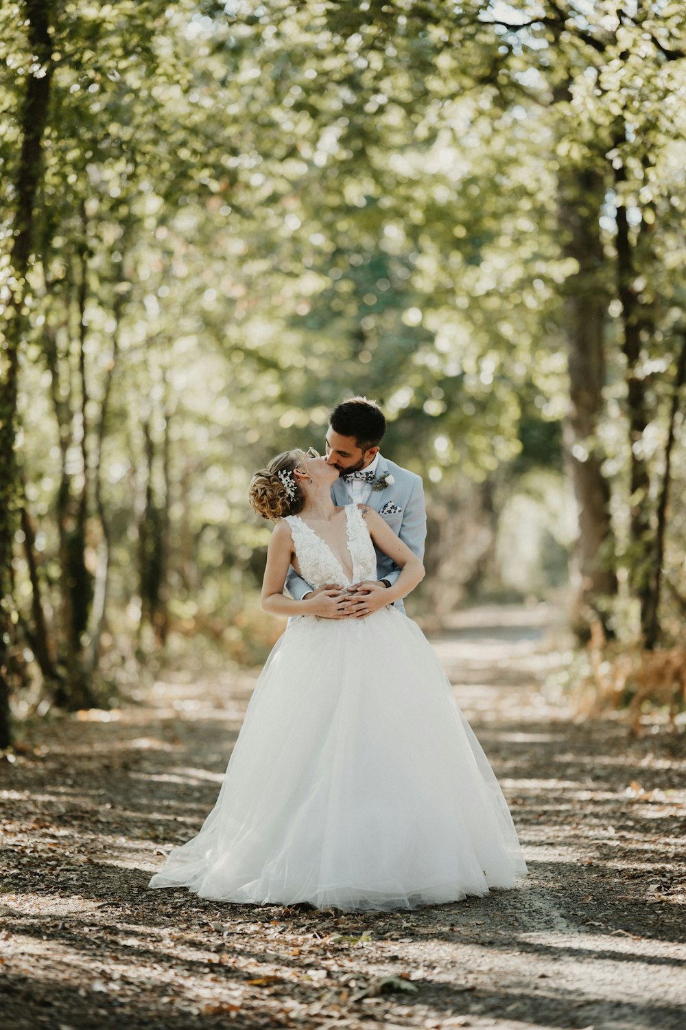 a bride and groom standing in the middle of a forest