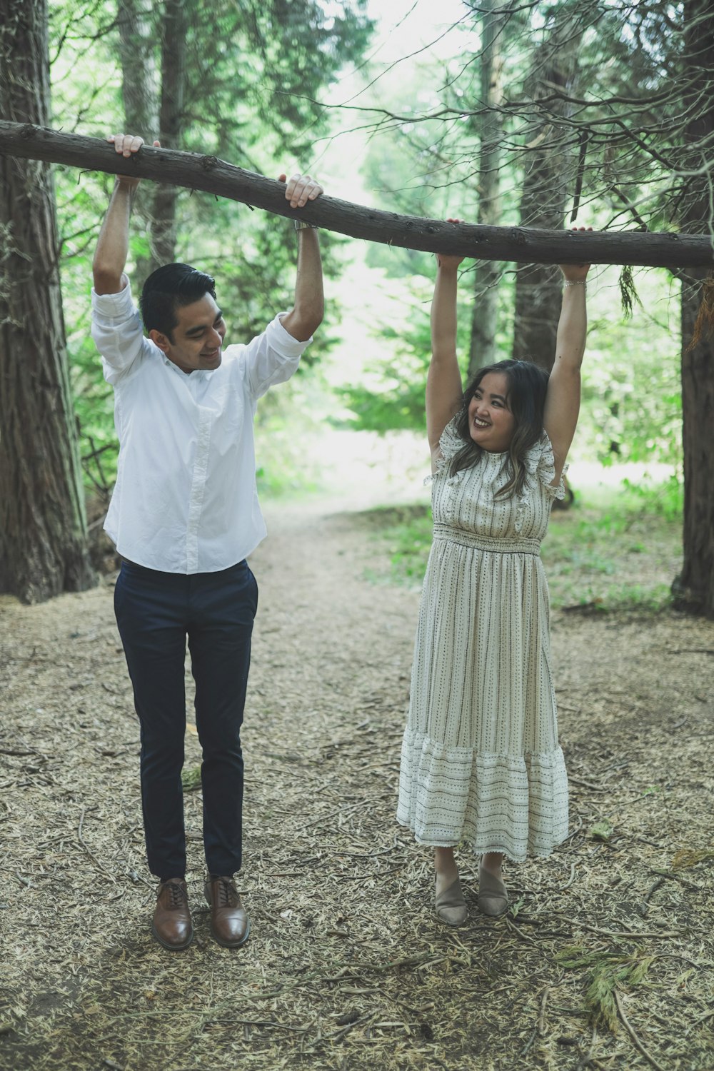 a man and a woman holding a tree branch