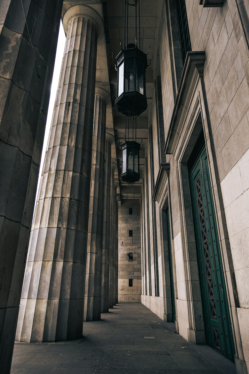 a building with columns and a light hanging from the ceiling