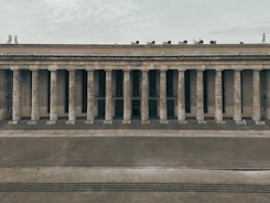a large building with columns and a sky background