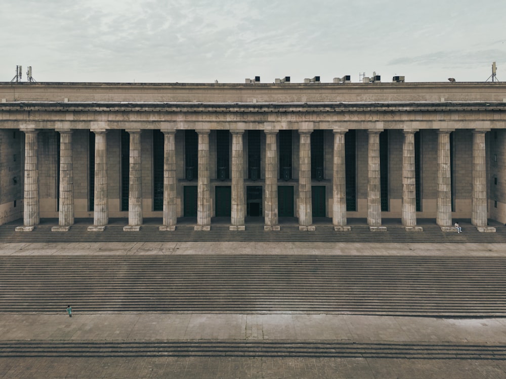 a large building with columns and a sky background