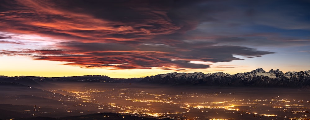 Una vista de una ciudad y montañas por la noche