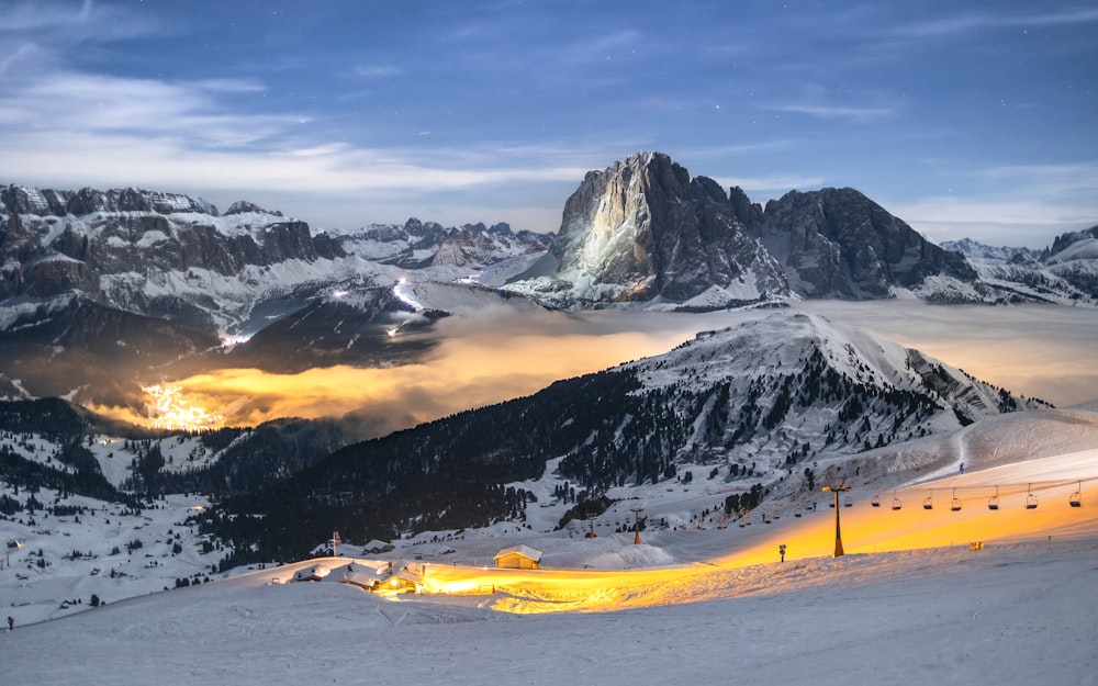 a view of a snowy mountain range with a bright light in the foreground