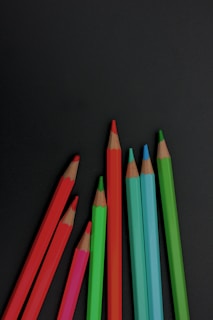 a group of colored pencils sitting next to each other