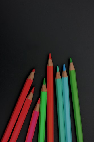 a group of colored pencils sitting next to each other