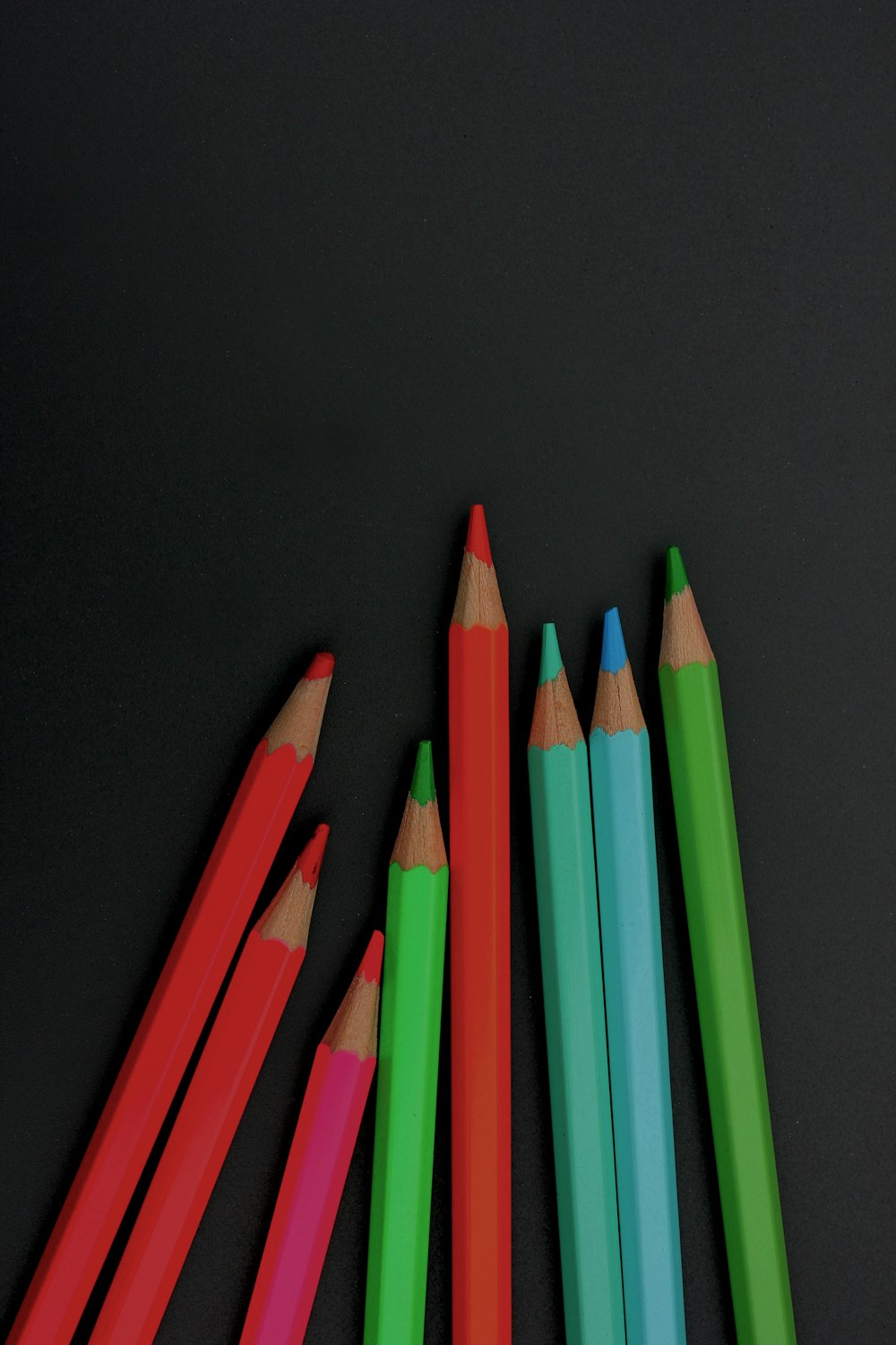 a group of colored pencils sitting next to each other