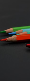 a group of colored pencils sitting on top of a table