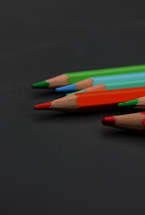 a group of colored pencils sitting on top of a table