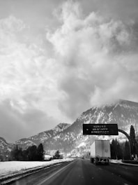 Photo of a snowy mountain road with road condition icons overlay.