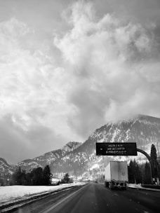 Photo of a snowy mountain road with road condition icons overlay.