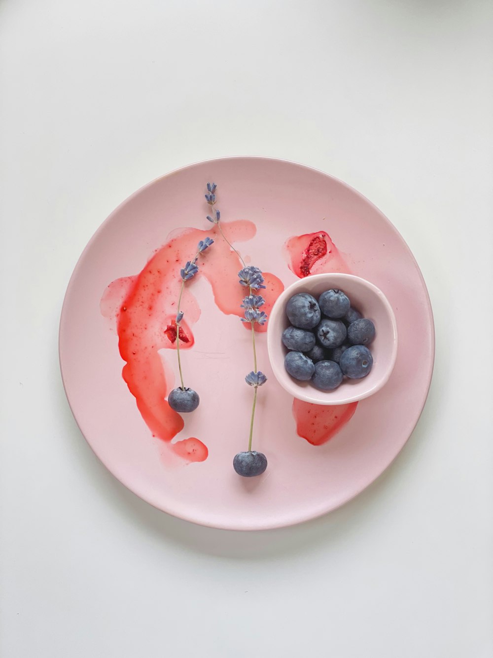a plate with blueberries and strawberries on it