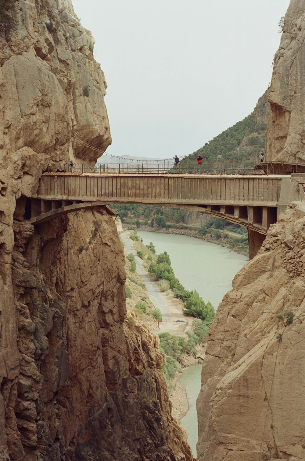 a bridge over a river between two mountains