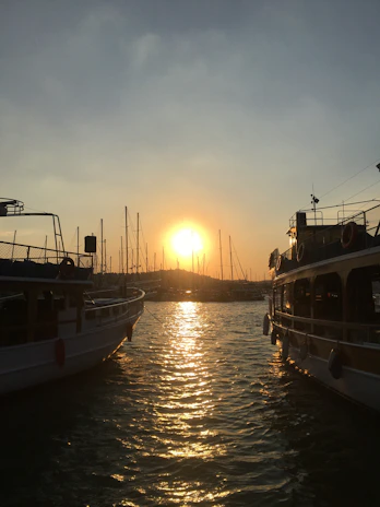 A sleek, cinematic shot of a luxury yacht at sunset, capturing golden light reflecting on the water.