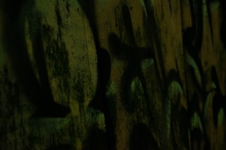 Dark urban mural with vivid red and blue graffiti elements under moody lighting.