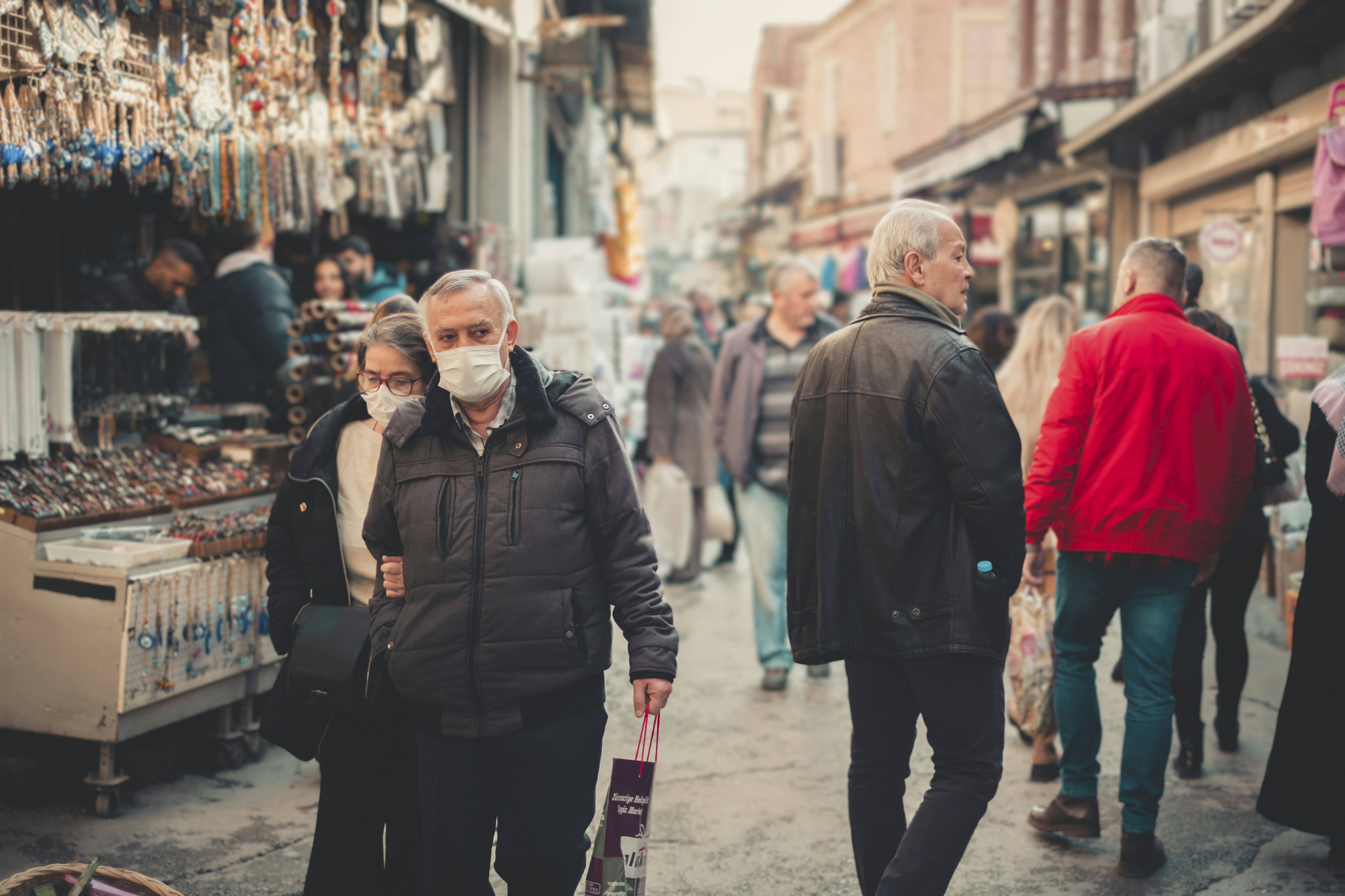 a group of people walking down a street next to shops