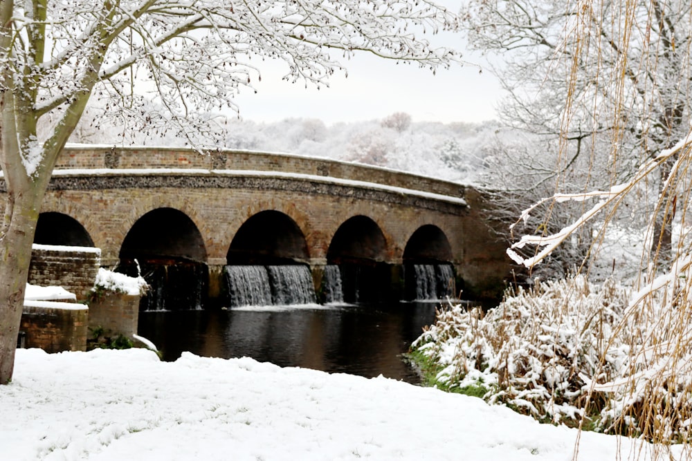 a bridge over a river with snow on the ground