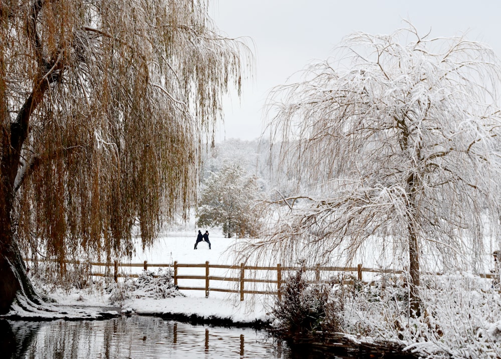 a man walking across a snow covered bridge