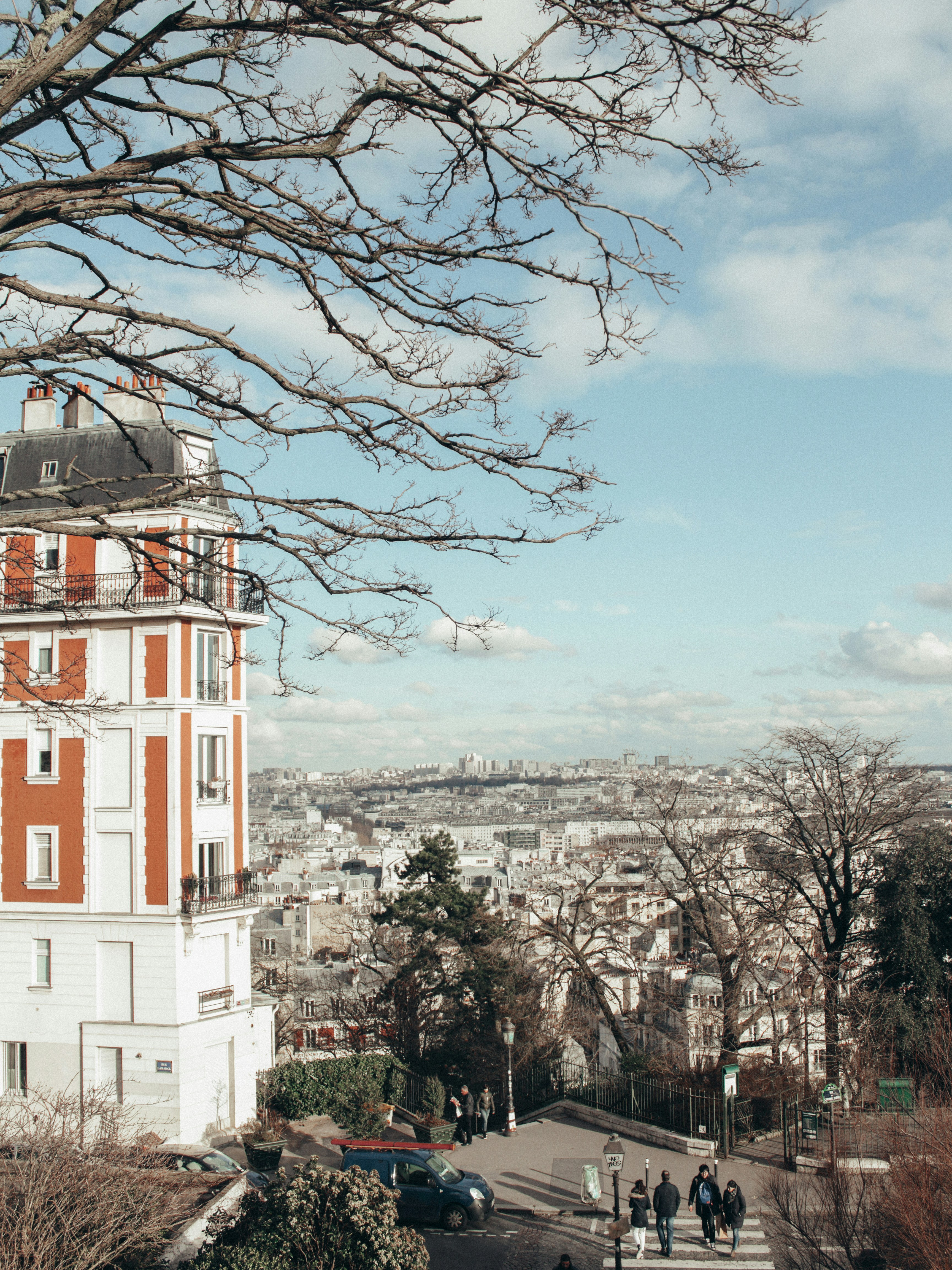 a group of people walking down a street next to a tall building