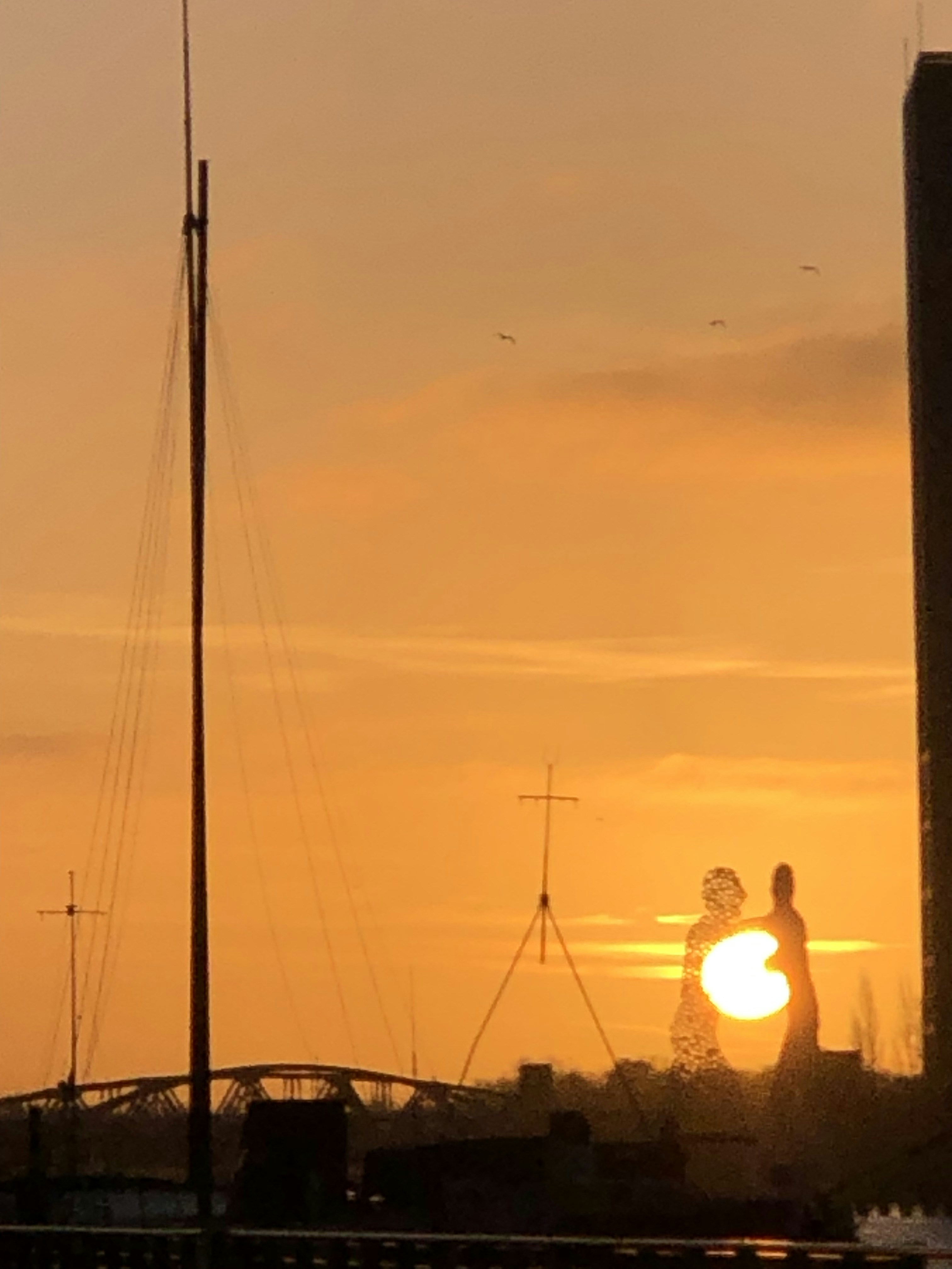 Le soleil se couche derrière un grand bâtiment