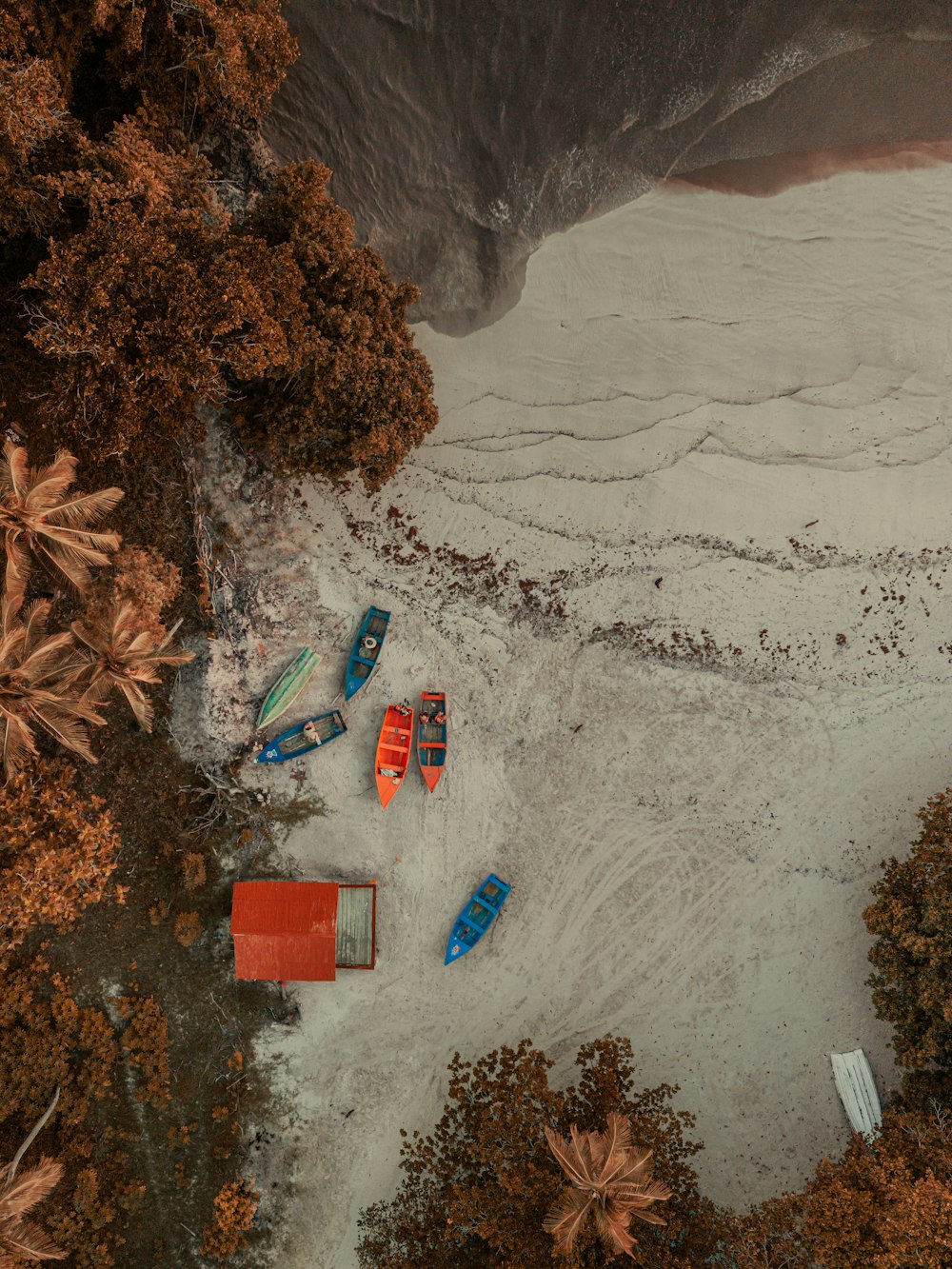 a group of boats sitting on top of a sandy beach