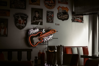 Interior of a rock-themed burger restaurant with neon lights and vintage rock memorabilia on the walls