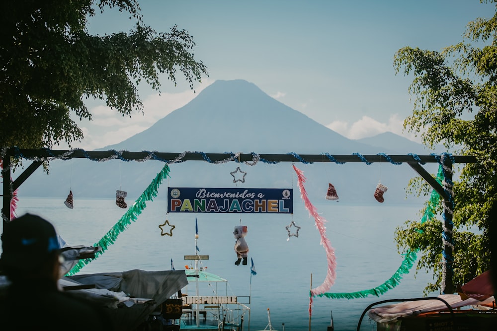 a group of people standing around a lake with a mountain in the background