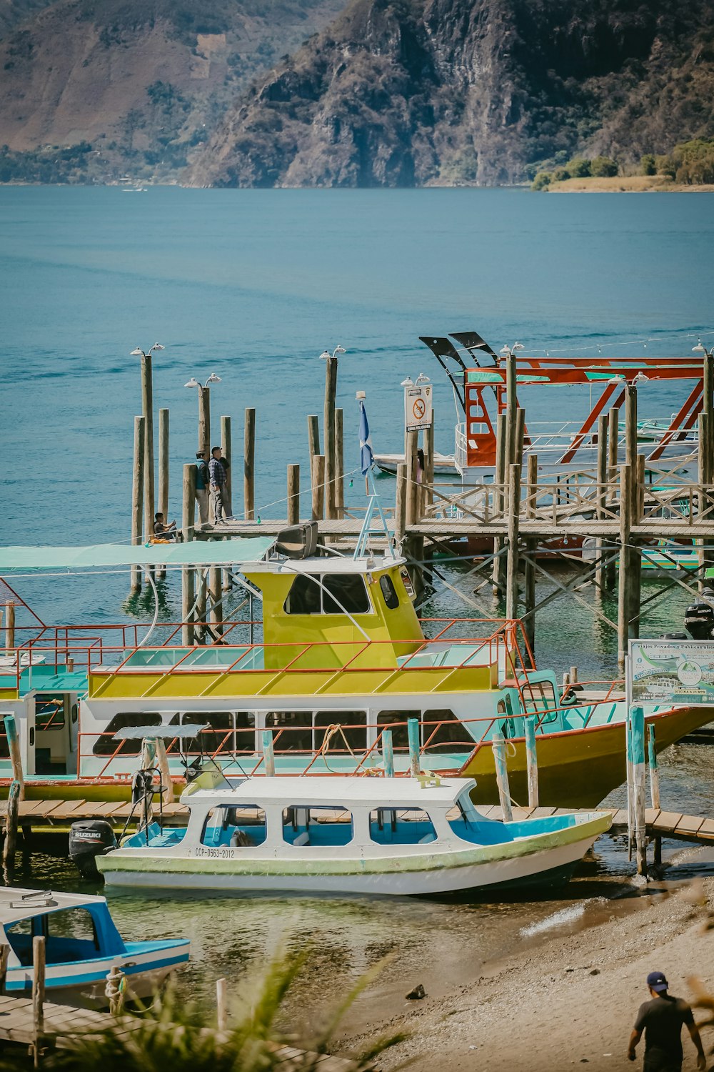 a yellow and blue boat docked at a pier