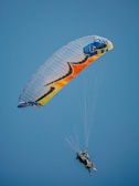two people are parasailing in the blue sky