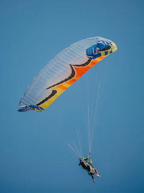 two people are parasailing in the blue sky