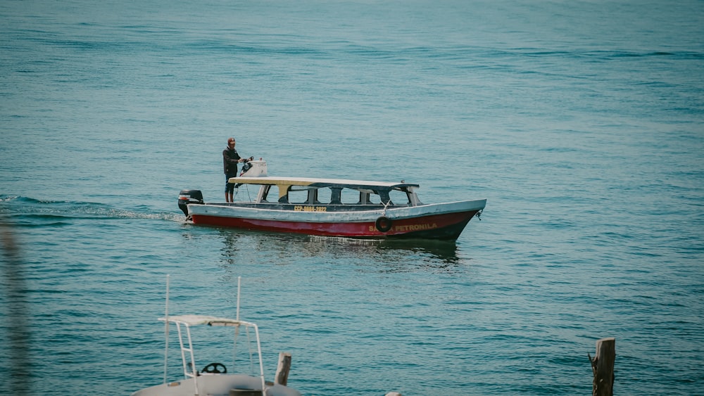 Un hombre parado en un bote en el agua
