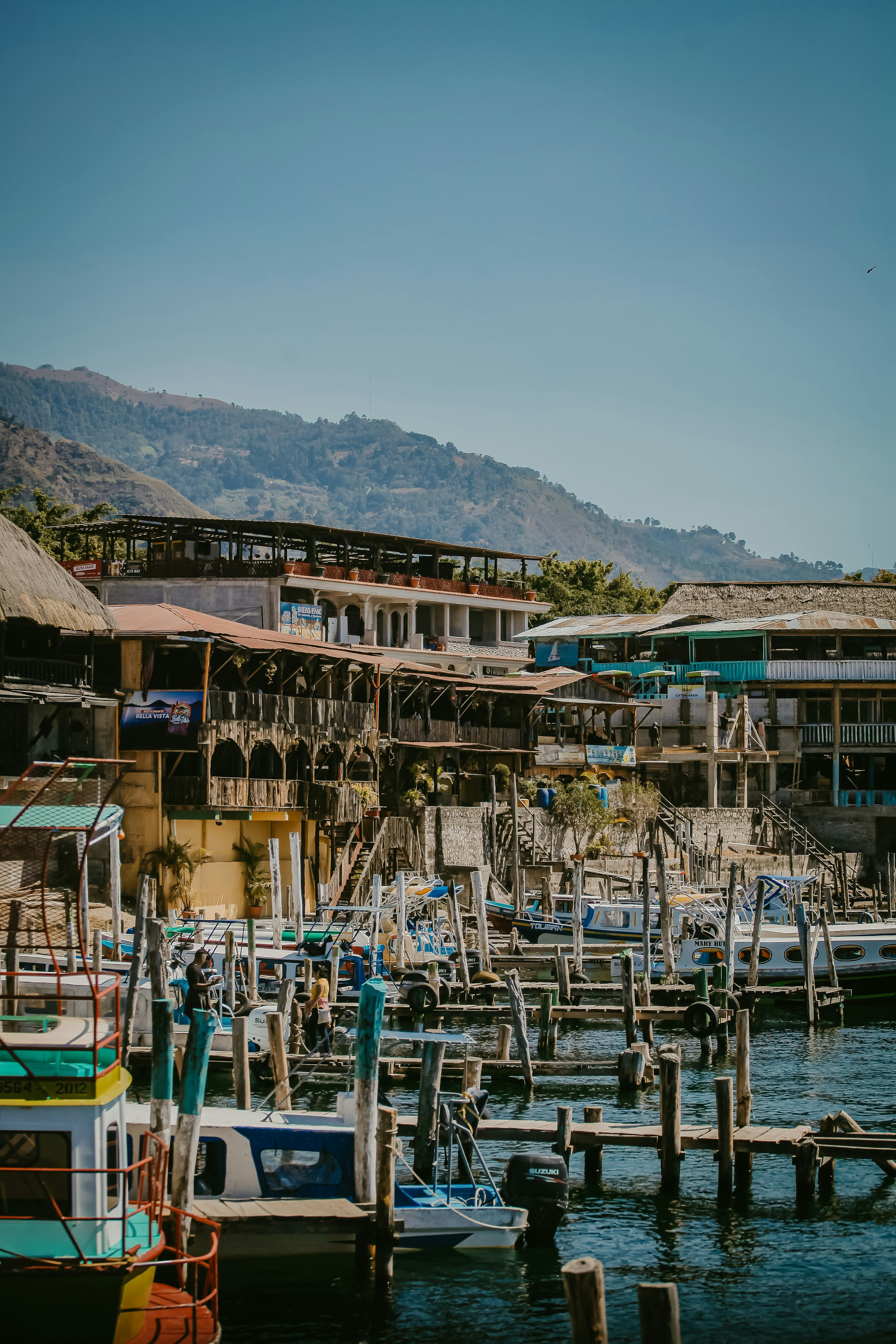 a harbor filled with lots of boats next to a mountain