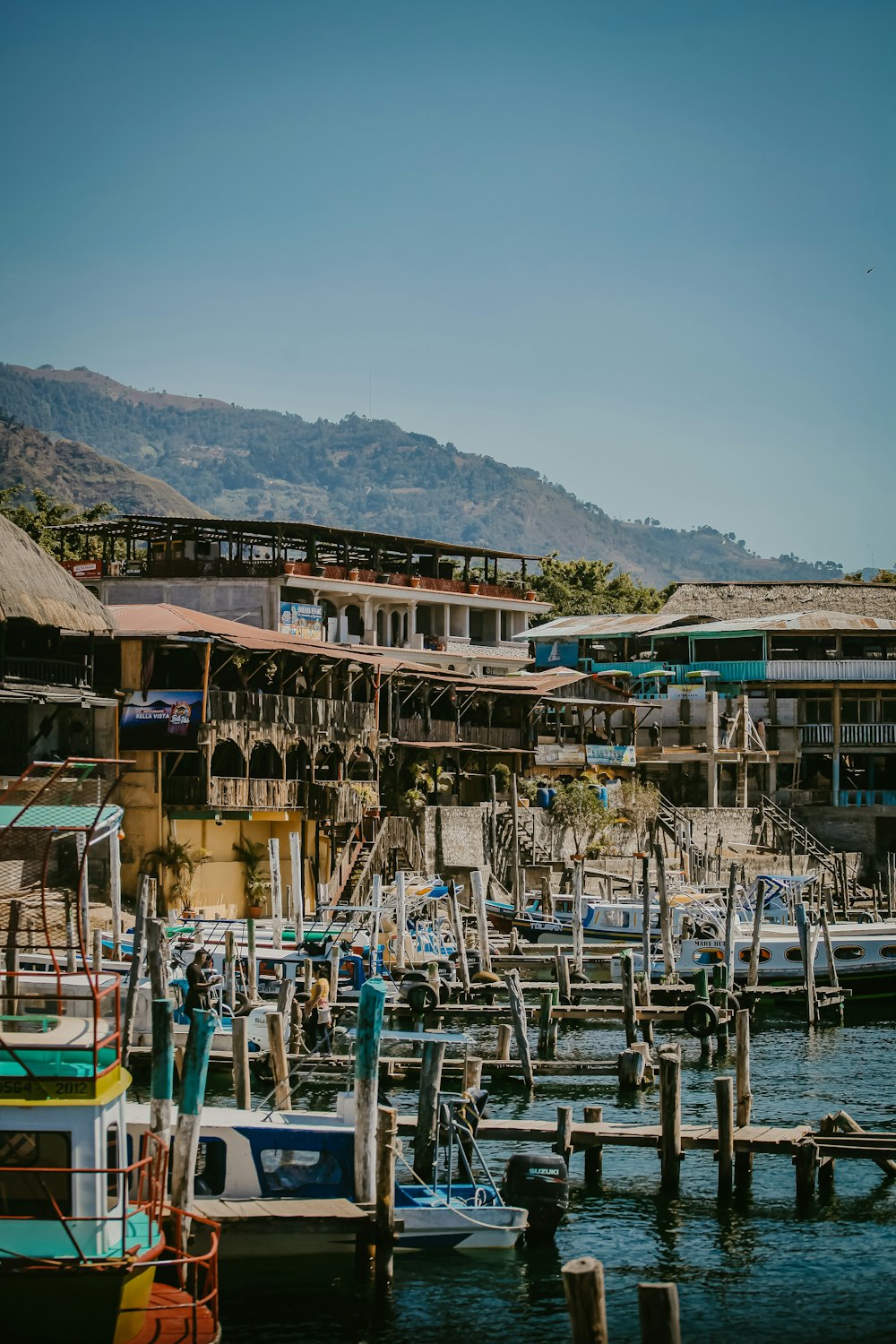 a harbor filled with lots of boats next to a mountain