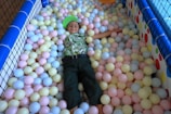 A vibrant ball pit filled with kids joyfully splashing and playing under soft pastel lights
