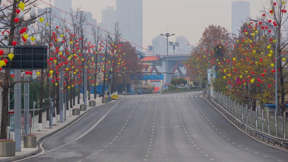 an empty street with a bunch of balloons on the trees