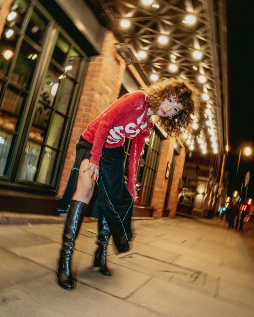 a woman in a red shirt is riding a skateboard