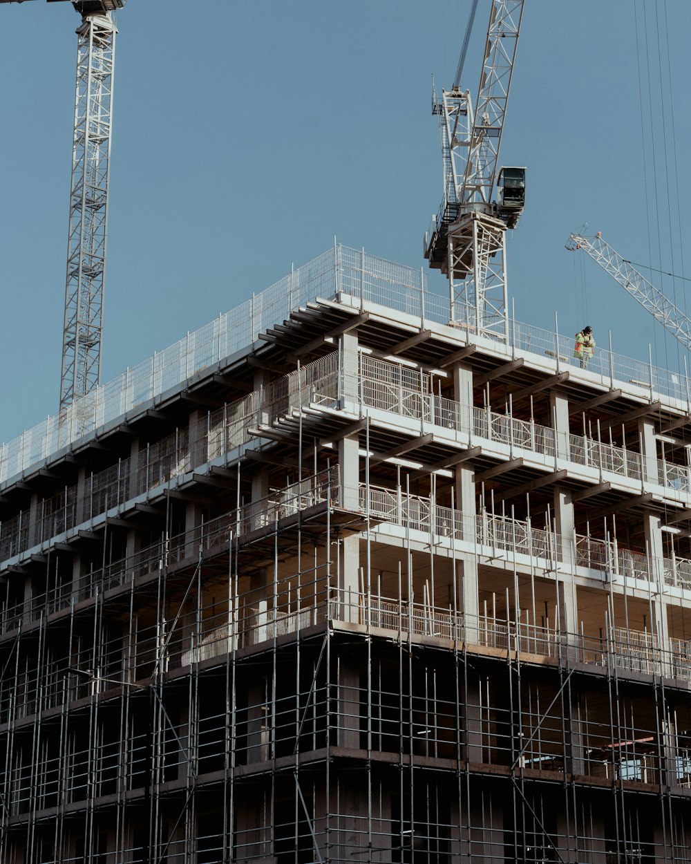 a crane is standing on top of a building under construction