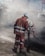 Two construction workers wearing reflective orange suits and white helmets are working on a road at night. One is holding a shovel while the other is engaged in raking or smoothing the asphalt. The scene is enveloped in a cloud of dust and smoke from the construction work.