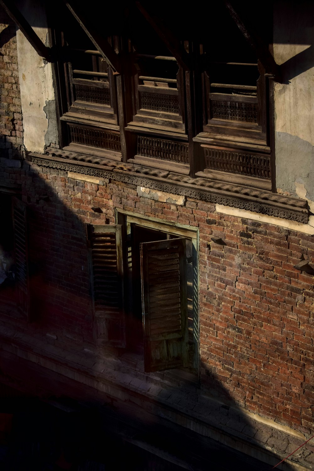 a brick building with open windows and shutters