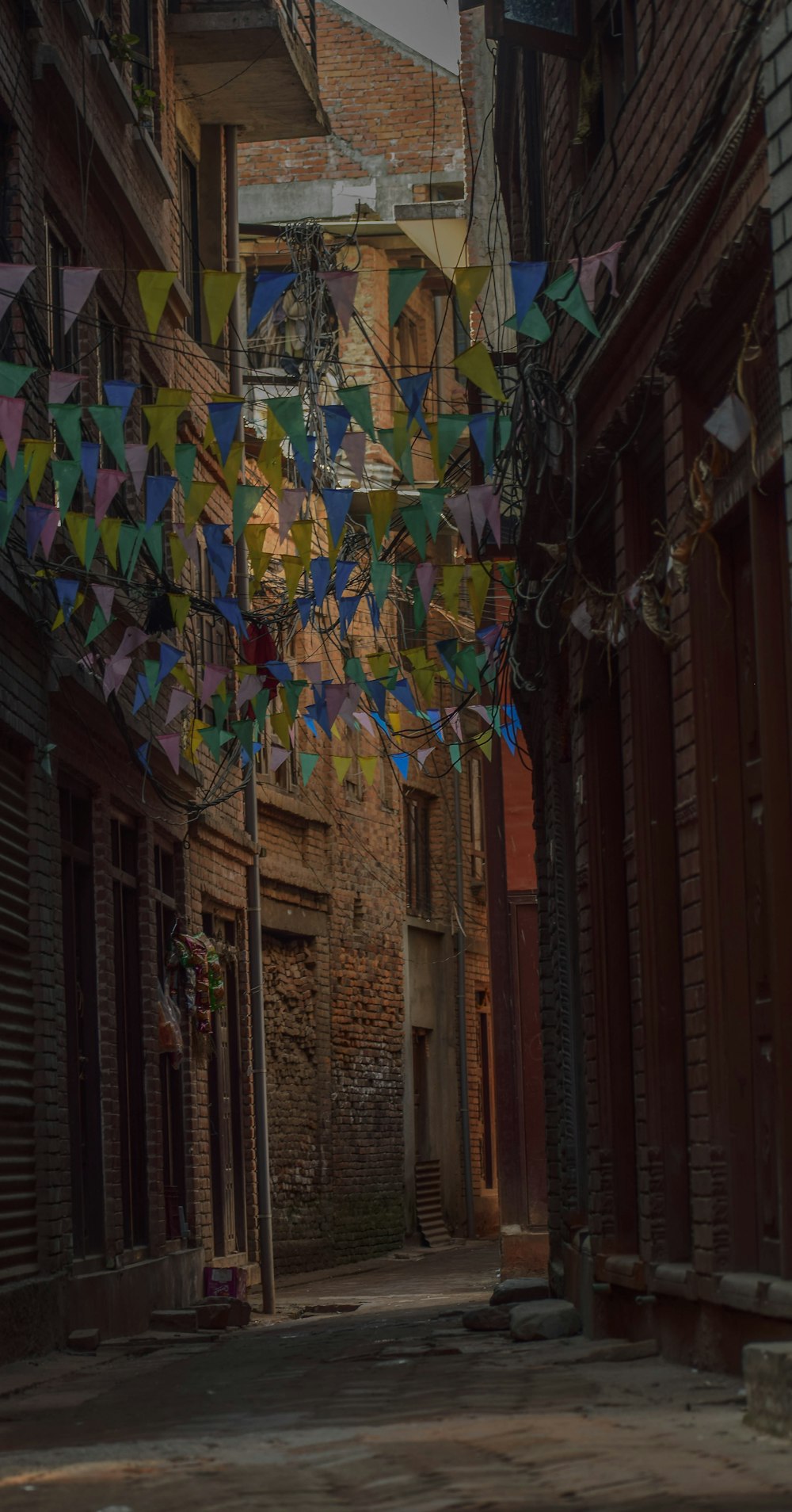 a street with a bunch of colorful flags hanging from it's sides