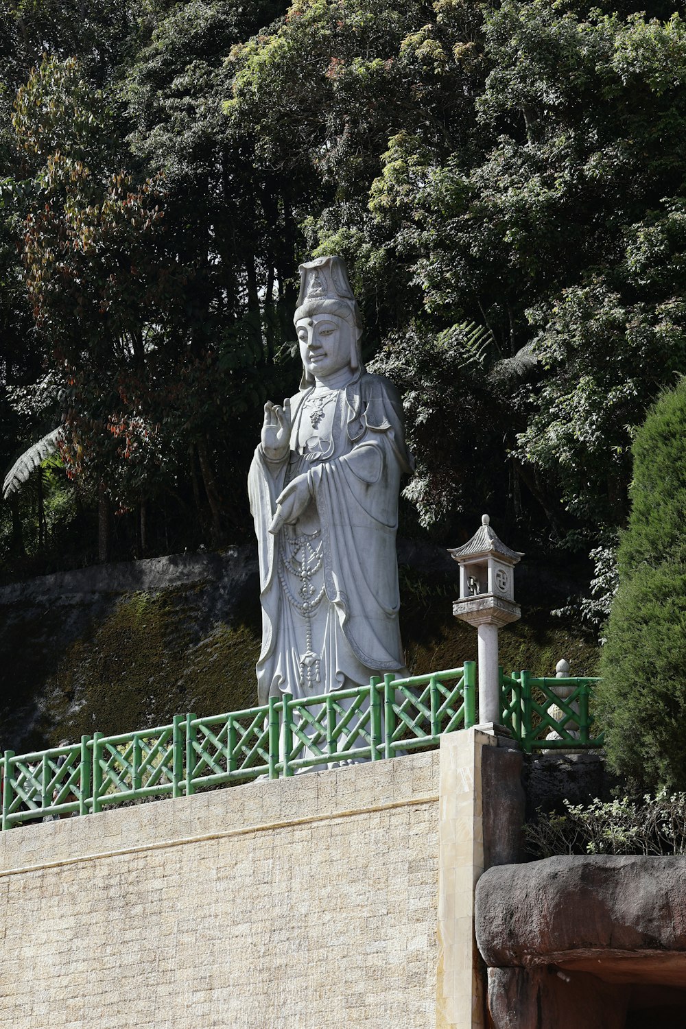 a statue of a person holding a bird on a bridge