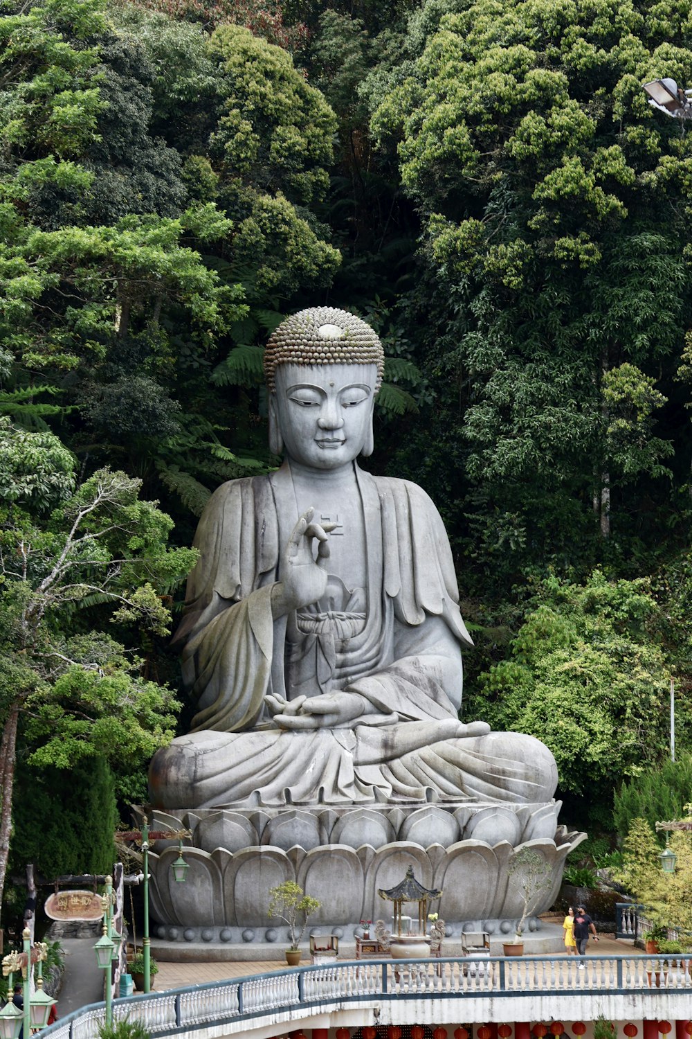 Una gran estatua de Buda sentada en medio de un parque