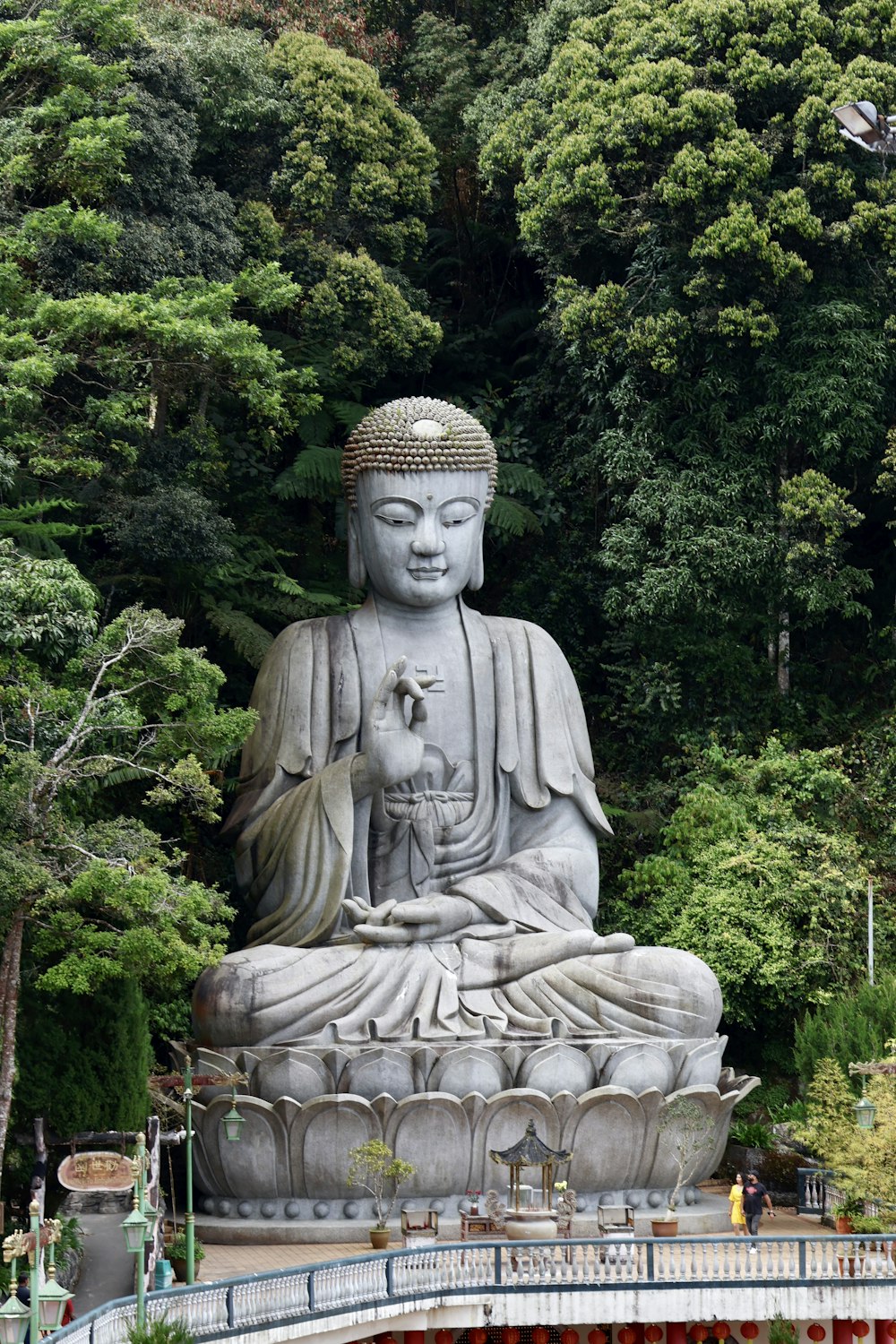 a large buddha statue sitting in the middle of a park